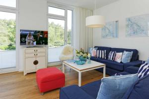 a living room with a blue couch and a table at Kapitaensweg 4 Koje 03 in Ostseebad Karlshagen