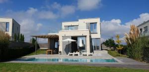 uma casa branca com uma piscina em frente em Villa Cape Vergoti em Lozenets