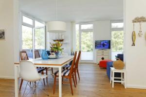 a dining room and living room with a table and chairs at Kapitaensweg 4 Koje 03 in Karlshagen