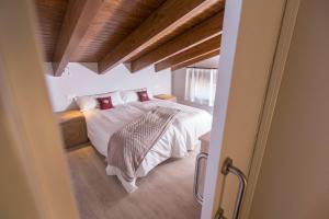 Un dormitorio con una cama con sábanas blancas y almohadas rojas. en Senda del Cabrerizo, en Albarracín