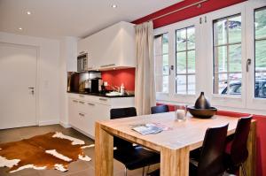 cocina y comedor con mesa de madera y sillas en Apartment Felix - GRIWA RENT AG en Grindelwald