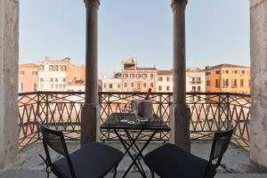 a table and chairs on a balcony with a view at Palazzo Cendon Piano Antico in Venice