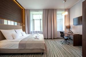 um quarto de hotel com uma cama grande e uma secretária em Plaza Boutique Hotel em Cracóvia