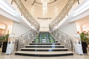 a spiral staircase in a lobby with a stair railing at Hotel Woiński Spa in Lubniewice