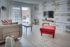 a living room with a couch and a red stool at Apartamento Avitan in Adeje