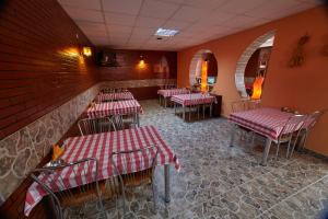 een restaurant met rode en witte tafels en stoelen bij Pensiunea Daniel in Sibiu