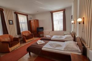 a hotel room with two beds and two chairs at Pensiunea Daniel in Sibiu