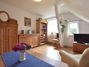 ein Wohnzimmer mit einer Vase mit Blumen auf einem Tisch in der Unterkunft Romantische Ferienwohnung in Boldenshagen in Boldenshagen