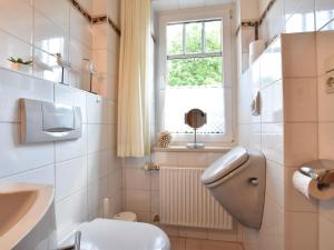 ein Badezimmer mit Toilette und Waschbecken und einem Fenster in der Unterkunft Romantische Ferienwohnung in Boldenshagen in Boldenshagen + 32 Fotos