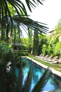 uma piscina com espreguiçadeiras num quintal em La Divine Comédie-Suites Deluxe em Avignon