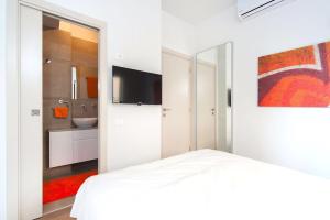 a white bedroom with a white bed and a bathroom at Frishman Dream by Five Stay in Tel Aviv
