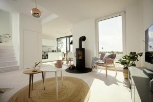 ein Wohnzimmer mit einem Holzofen und einem Tisch in der Unterkunft Villa White I in Fehmarn