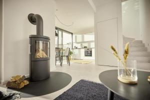 a fireplace in a living room with a table at Villa Azure I in Fehmarn