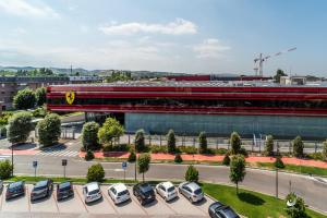 a train in a parking lot in front of a building at Planet Hotel in Maranello