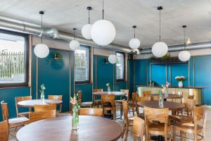 a dining room with tables and chairs and blue walls at Niebo do wynajęcia in Łukta