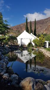 ein großer Teich mit einem weißen Gebäude im Hintergrund in der Unterkunft Montagu Little Sanctuary - Hot Spring Access at reduced price in Montagu