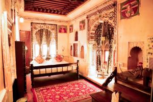 Habitación con banco y alfombra roja en Singhvi's Haveli, en Jodhpur