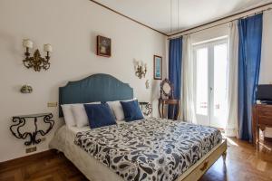 ナポリにあるPaolino's Balconyのベッドルーム1室(大型ベッド1台、青いヘッドボード付)