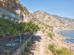 a building on the side of a mountain next to the water at Sweet Corner Masxali in Agia Roumeli