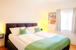 a bedroom with a large bed with green and white pillows at Villa Leopoldskron in Salzburg
