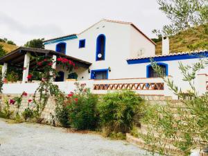 una casa con flores y paredes azules y blancas en CASA RURAL DE ENSUEÑO, en Almuñécar