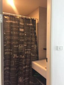 a bathroom with a shower curtain with writing on it at nest condo in Ban Bang Toei (1)