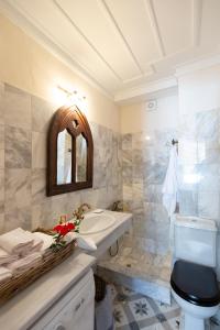 a bathroom with a sink and a toilet and a mirror at Villa of the old olive oil factory in Ágios Konstantínos