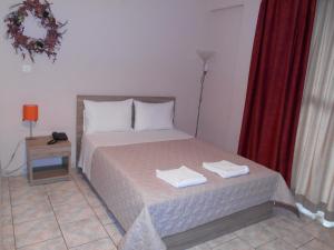 una camera da letto con un letto e due asciugamani di Hotel Vasilis a Nauplia