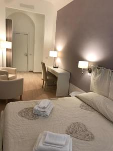 a hotel room with a bed, chair, and nightstand at B&B Sallustio Rooms in Siena