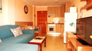 ein Wohnzimmer mit einem blauen Sofa und einer Küche in der Unterkunft In Las Americas with amazing view in Playa de las Americas