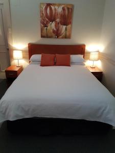 a hotel room with two beds and a lamp at Highlands Hotel in Mittagong