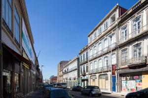 una fila de edificios en una calle de la ciudad con coches en LovelyStay - Oren Duke's House en Oporto