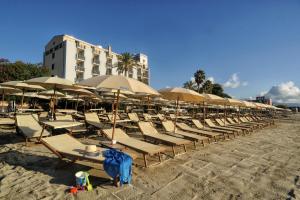a row of chairs and umbrellas on a beach at Mare Hotel in Savona