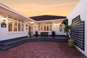 a house with a brick patio in front of it at Carslogie House in Port Elizabeth