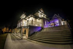 duży dom ze schodami z przodu w nocy w obiekcie NovaWisła Resort & SPA w Wiśle