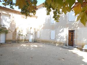 un bâtiment blanc avec un banc devant lui dans l'établissement MAS PROVENCAL LE ROCAn, à Aubignan