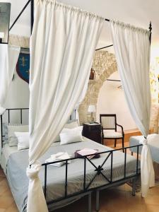a bedroom with a bed with white curtains at La Torre Storica in Bitonto