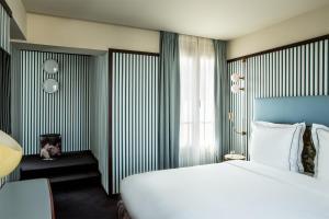 パリにあるHôtel du Rond-point des Champs-Élysées - Esprit de Franceの大きな白いベッドと窓のある寝室 +37枚の写真
