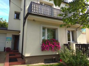 een huis met een balkon met roze bloemen erop bij Olive Hostel in Gdańsk