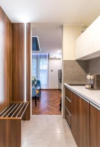 a kitchen with wooden cabinets and a living room at Onyx luxury apartments in Belgrade