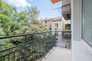 a balcony with a black railing and trees at blueWaveplace - Contemporary Home in Center of Sofia in Sofia