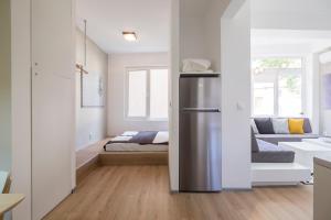 a kitchen with a refrigerator in the middle of a room at blueWaveplace - Contemporary Home in Center of Sofia in Sofia