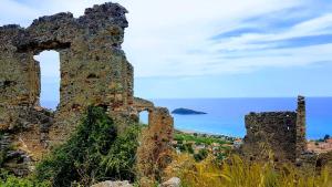 an old stone building with the ocean in the background at Villa Crawford in San Nicola Arcella