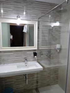 a bathroom with a sink and a shower and a mirror at Hotel Bruselas in A Guarda