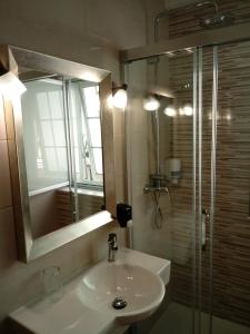 a bathroom with a sink and a shower with a mirror at Hotel Bruselas in A Guarda +29 photos