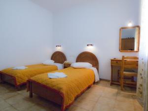 a hotel room with two beds and a mirror at Hotel Lofos - The Hill in Ios Chora