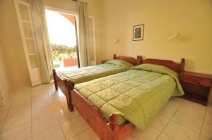 a bedroom with a bed and a large window at Elena Apartments Corfu in Acharavi +33 photos