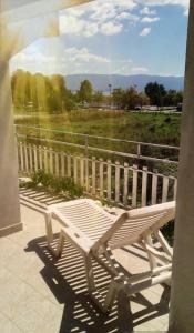 a white bench sitting on a balcony looking out at a field at Marko Apartments in Struga