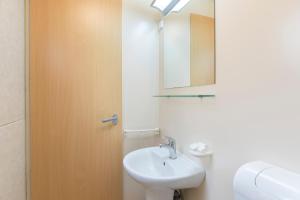 a white bathroom with a sink and a mirror at The Camp by Maggiore Suites in Maccagno Inferiore