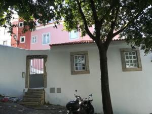 リスボンにあるSoul House - Exclusive Apartmentの白ピンクの家の前に停められたオートバイ